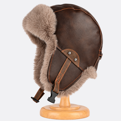 Brown aviator hat on a stand, showing faux fur earflaps and a stitched side panel
